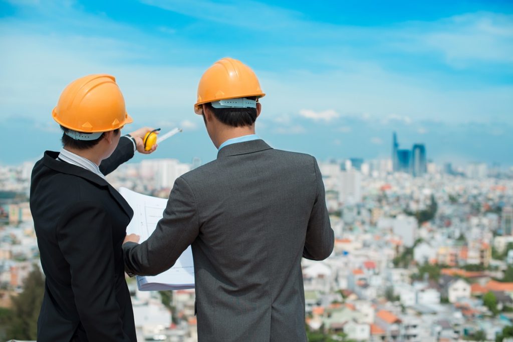 Businessmen in hardhat looking at a blueprint