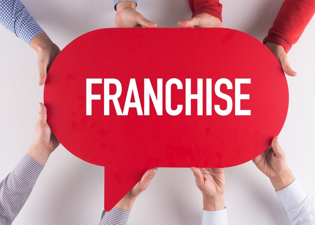 Group of People Holding Franchise Text