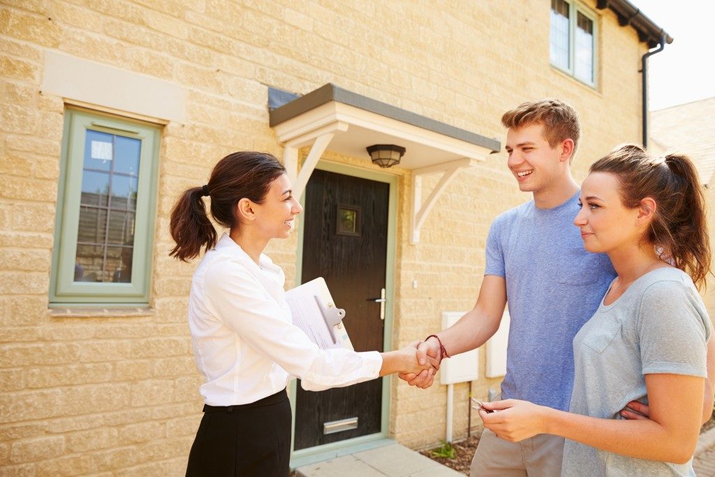 House broker shaking hand of tenants