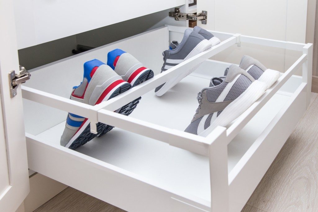 Inner drawer in a cupboard with divider and holder especially for shoes