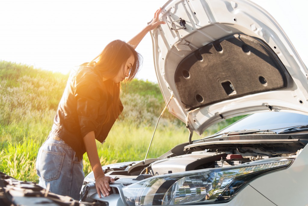 woman checking the engine of her car