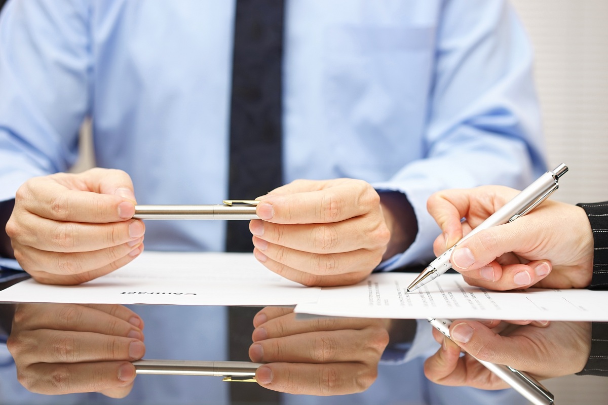 two men signing a paper