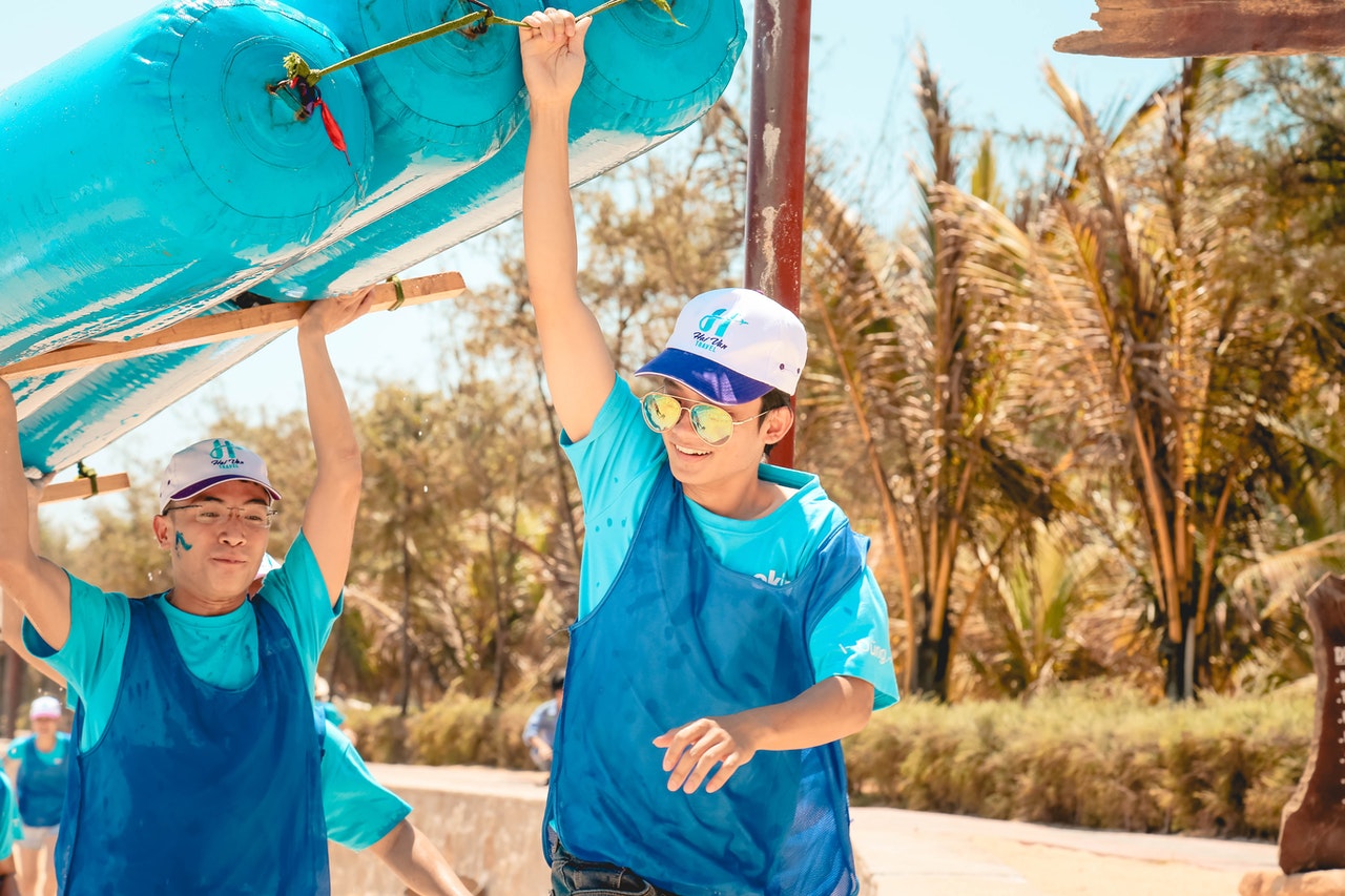 two people carrying a raft